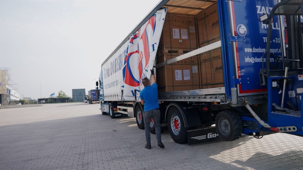 Chauffeur bij een geopende GD-iTS-trailer die wordt geladen