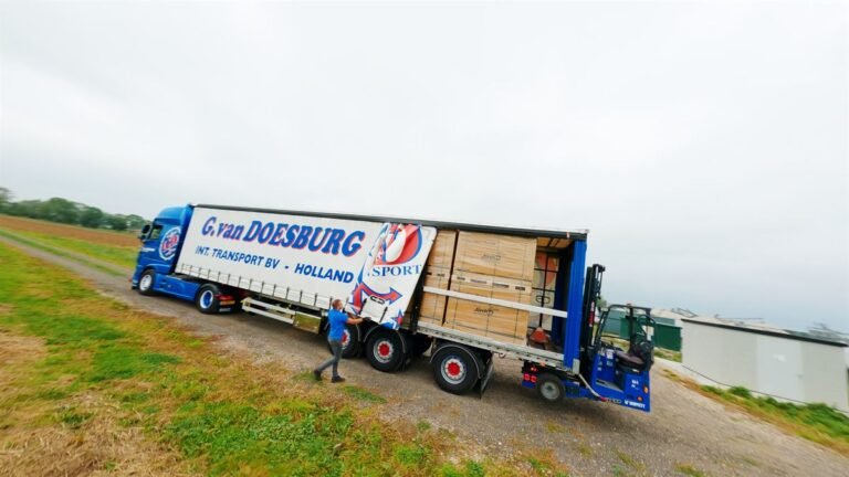 GD-iTS-vrachtwagen met oplegger rijdt over een dijk door het polderlandschap