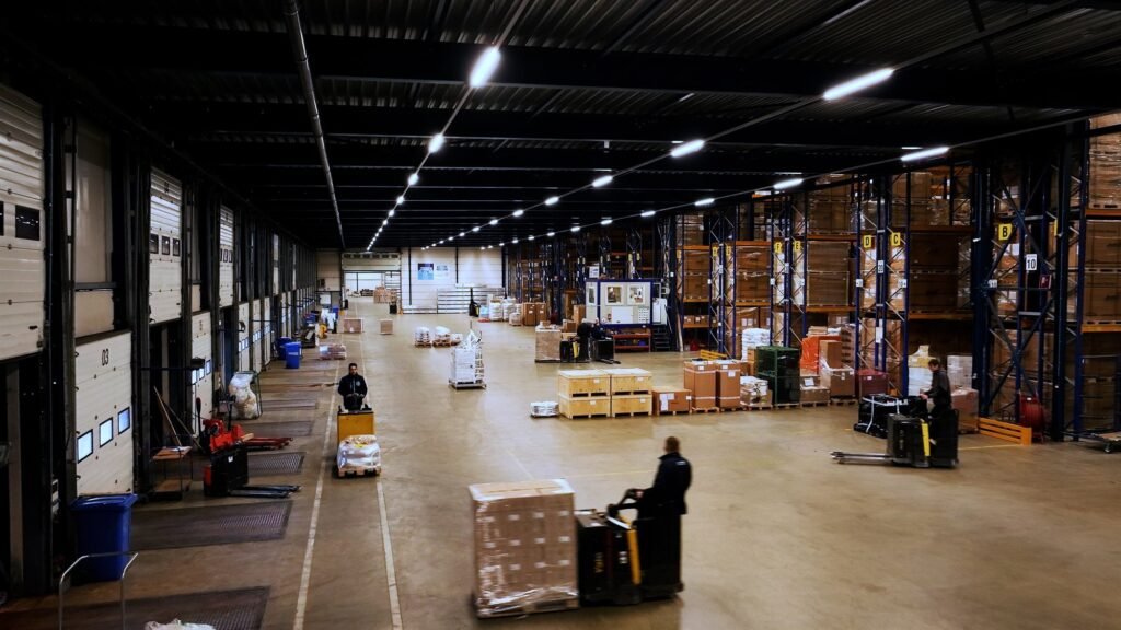 Medewerkers aan het werk in een ruime warehousehal van GD-iTS, met pallets en laaddocks